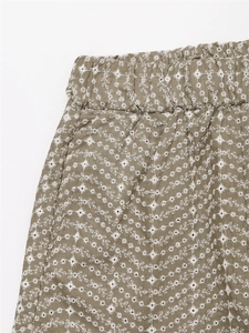 Détail de la taille élastique et broderie florale blanche sur short en coton et lin