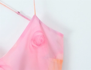 Gros plan sur une robe fleurie rose avec fines bretelles réglables et décolleté volanté