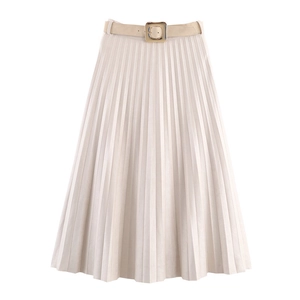 Close-up of pleated midi skirt featuring a faux suede effect and gold buckle belt detail