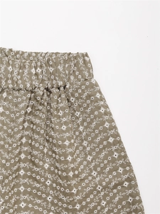 Détail d'un short vert olive avec broderies marguerites blanches et une taille élastique