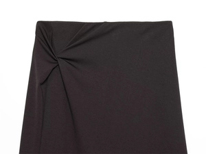 Close-up of black high-waisted skirt featuring a stylish side twist knot and draped detail