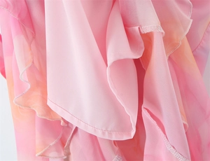 Détails macro du tissu mousseline dégradé rose avec volants et finitions d'ourlet roulé