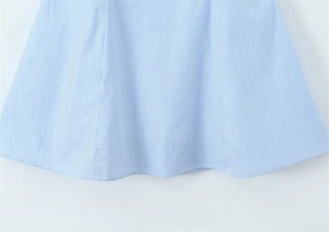 Detailed close-up of blue and white striped fabric hem with fine stitching and A-line cut