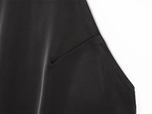 Macro detail of high-quality black fabric showing reinforced diagonal stitching and clean seams