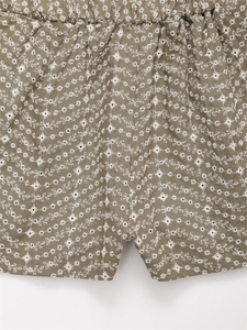 Gros plan détaillé du short vert olive avec broderies florales blanches et taille élastique