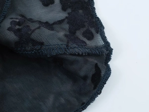 Détail macro du tissu en maille noire avec flocage élégant et coutures précises