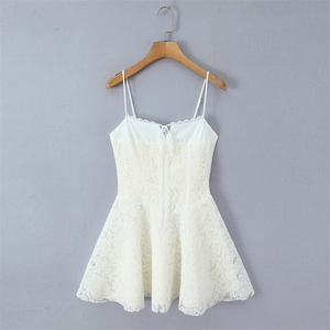 Detail of cream lace dress featuring delicate floral embroidery and a small bow tie