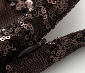 Macro shot of invisible zipper and sequin texture on brown halter neck evening gown