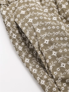 Détail de la broderie florale blanche et poche latérale sur short d'été kaki