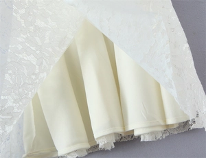 Close-up of intricate floral white lace fabric with smooth inner lining detail