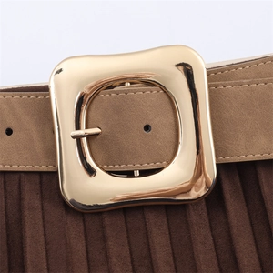 Close-up of a wide khaki suede belt with a polished square gold buckle and pleated fabric