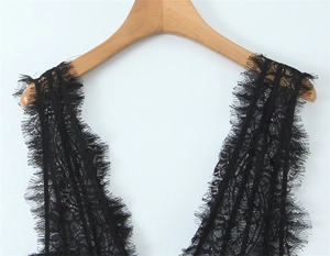 Detailed view of black floral lace with delicate eyelash trim on a wooden hanger