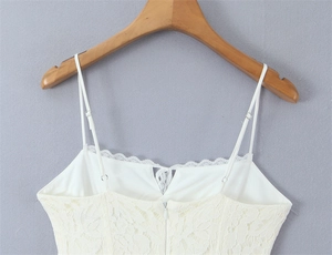 Detailed view of cream lace camisole top with floral embroidery and adjustable straps