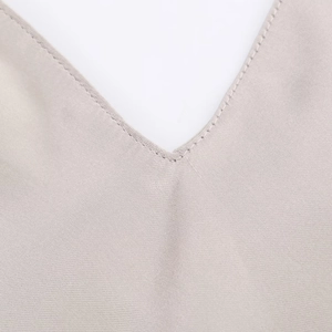 Macro shot of V-neckline featuring precise machine stitching on satin fabric