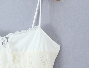 Close-up of elegant white floral lace stitching and adjustable thin straps on dress