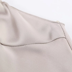 Detail of high-quality stitching and champagne satin fabric on a lace slip dress