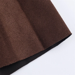 Macro detail of brown pleated midi skirt fabric with suede finish and black edge