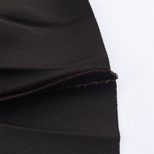 Detailed close-up of dark pleated fabric showing high-quality stitching and fiber texture