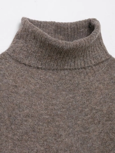 Macro di un abito corto in maglia marrone con collo alto e consistenza in morbida lana
