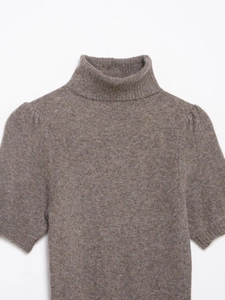 Dettaglio del vestito in maglia tortora con collo alto e consistenza morbida