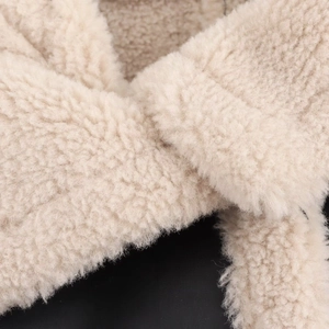 Macro view of creamy white faux shearling texture on a winter jacket inner lining