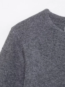 Détail du tissu tricoté gris avec texture grainée et coutures de qualité sur le col
