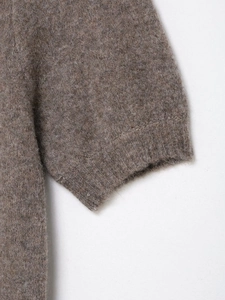 Dettaglio del polsino a coste e della morbida trama a maglia di questo vestito marrone