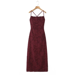 Macro detail of burgundy lace dress showing floral jacquard texture and strappy back design