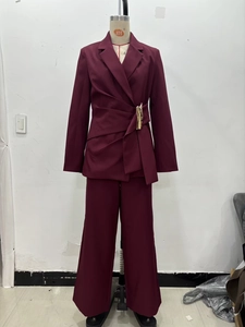 Détail d'un tailleur bordeaux avec boucle dorée à la taille et drapé plissé chic