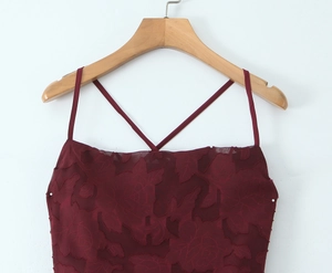 Detailed close-up of wine red jacquard leaf pattern fabric and slim crisscross straps
