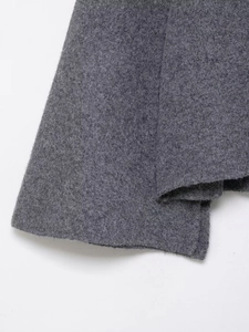 Vue détaillée de la texture du tricot gris foncé avec coutures et finitions de l'ourlet