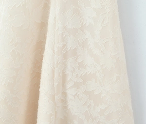 Gros plan détaillé du tissu de robe d'été beige avec texture jacquard florale 3D