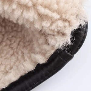Close-up of black PU leather jacket with thick beige faux shearling lining for warmth