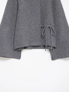 Détail du haut en maille gris foncé avec laçage latéral et finitions de l'ourlet