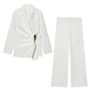 Détail de la taille du blazer blanc avec boucle en métal doré et texture plissée élégante