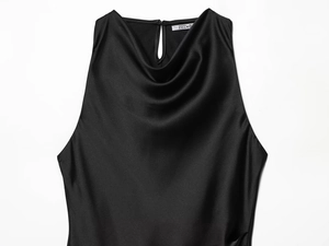 Detail of cowl neck design on black sleeveless satin dress with glossy silk texture