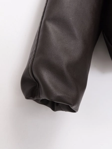 Detalle macro del puño de manga en cuero sintético marrón oscuro con costura fina