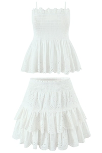 Detail of white eyelet cotton set with smocked crop top and tiered ruffle mini skirt