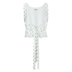 Detail of the back tie-up design with a large bow and black polka dots on a white top