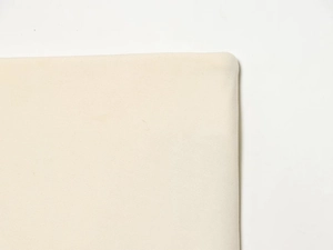 Detailed close-up showing the fine plain weave texture and smooth seam of the beige fabric skirt