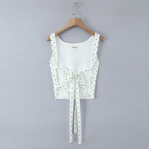 Detail of white black polka dot crop top featuring criss-cross back tie and bow detail