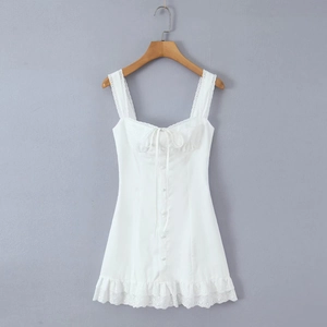 Close-up of white summer dress featuring lace trim square neck and tie front detail