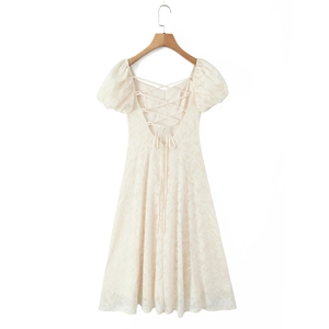 Vue détaillée du dos d'une robe crème à manches bouffantes avec bretelles croisées et dentelle