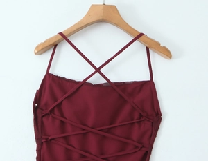 Detail of burgundy top featuring criss-cross back straps and floral lace texture