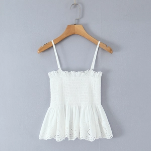 Detail of white cotton camisole top featuring smocked bodice and eyelet embroidery