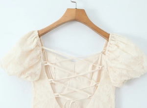 Détail des manches bouffantes et du tissu en dentelle sur une robe blanche d'été