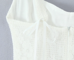Détail du tissu en dentelle florale blanche avec cordon en satin et fermeture éclair latérale