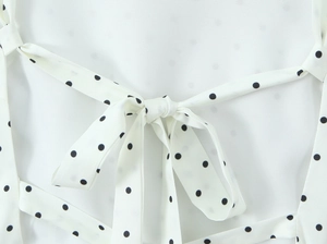 Detail of white black polka dot fabric showing back tie knot bow construction