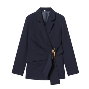 Détail du blazer bleu marine avec boucle dorée et drapé asymétrique élégant à la taille