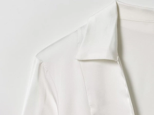 Close-up of a white satin shirt showing the smooth texture and lapel collar stitching